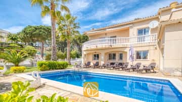Piscine extérieure privée à la Villa Estrella aux eaux bleues, avec chaises longues et palmiers sous un ciel bleu.