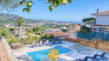 Piscine privée aux eaux bleues et chaises longues environnantes avec vue sur la ville et la mer à la Villa Abigail