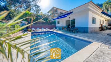 Piscine privée et terrasse de la Villa Zarita, dotées d'une eau aux reflets azur, de transats blancs et d'un coin repas extérieur abrité par un store bleu.
